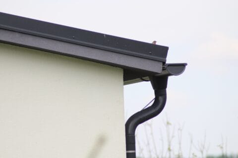 black,gutter,on,the,side,of,modern,white,house,with