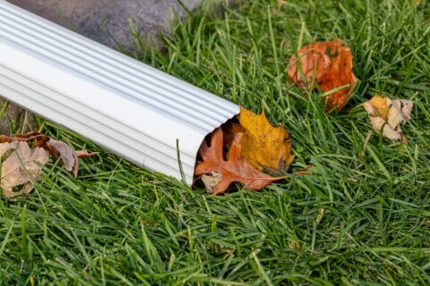 closeup,of,house,rain,gutter,downspout,clogged,with,colorful,leaves